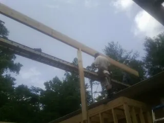 Carpenter setting a ridge beam over a new addition frame — Ice Dam Removal by Roofing Brothers in Monmouth Beach