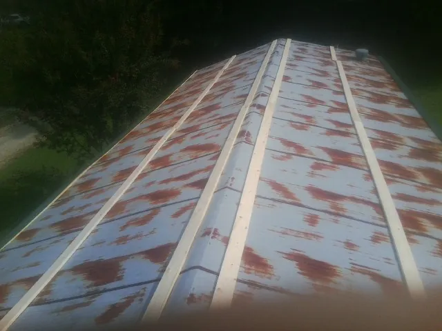 Rusted metal roof panels with new wood purlins before replacement — Storm Damage Roof Repair in Monmouth Beach by Roofing Brothers